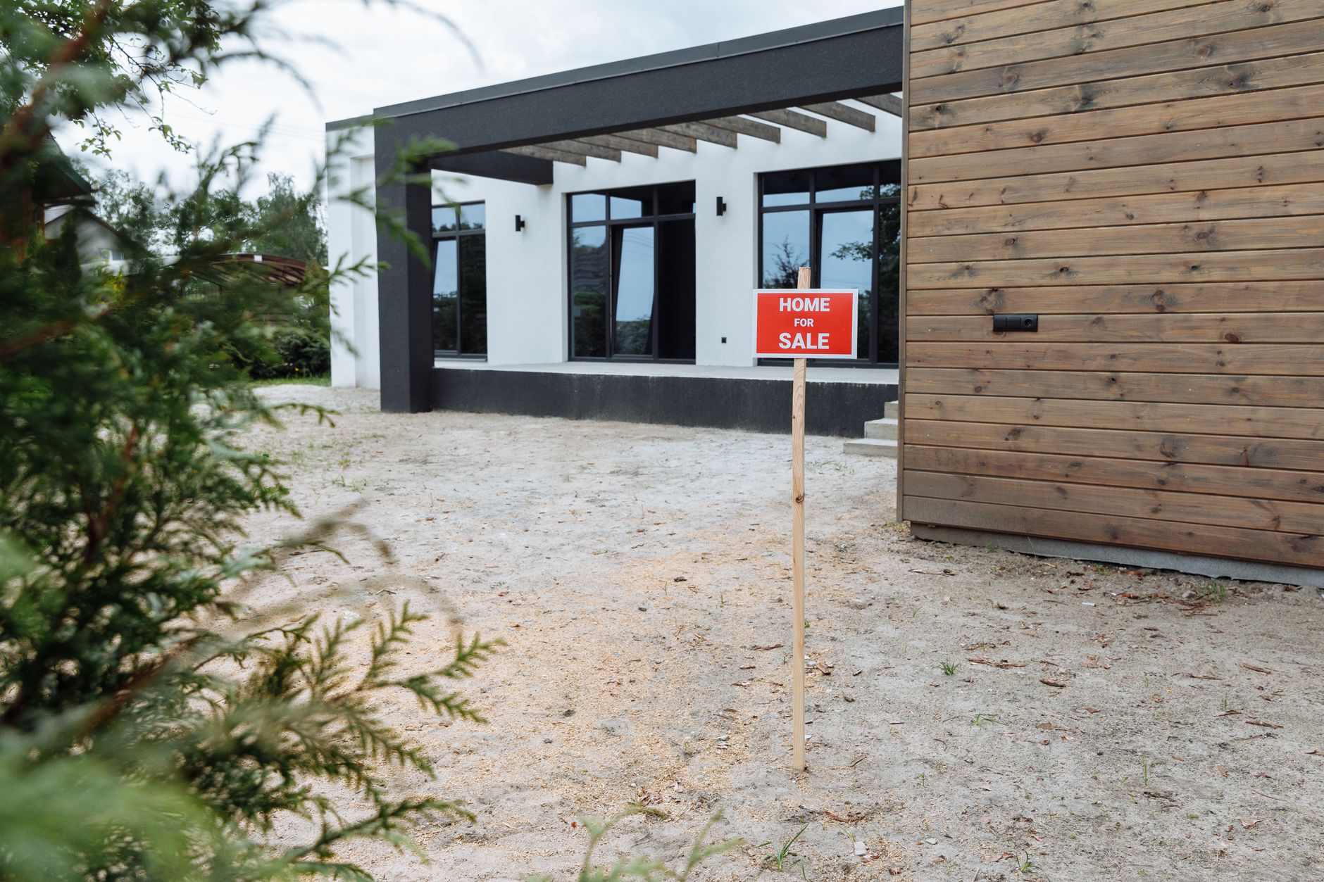 Home listed for sale with a sign in the front yard